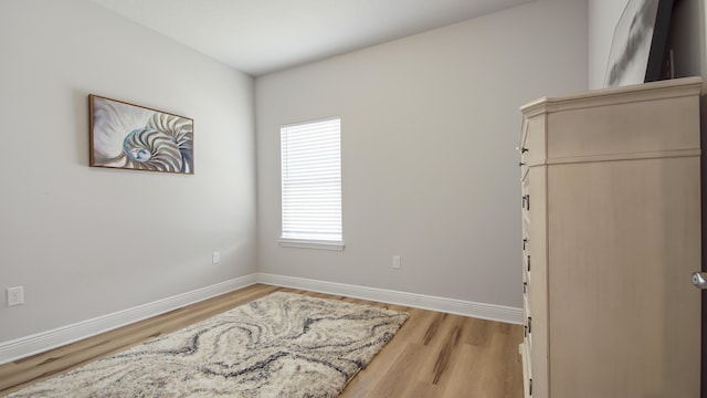 bedroom with light wood-type flooring and baseboards