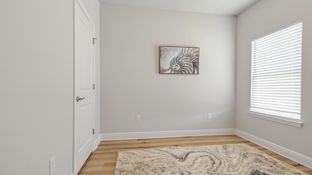 unfurnished room with light wood-type flooring and baseboards