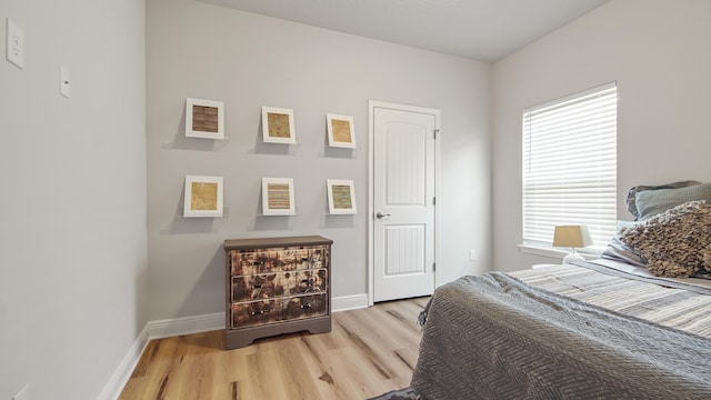 bedroom featuring light wood finished floors and baseboards