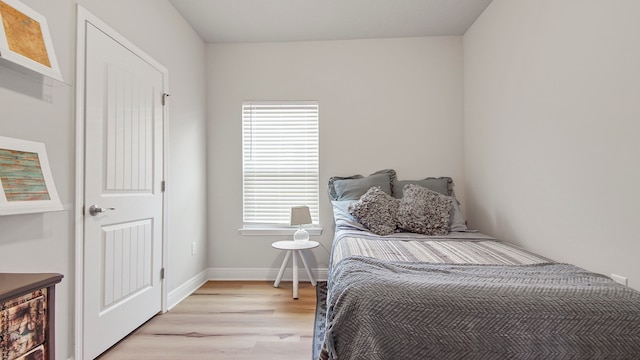 bedroom with light hardwood / wood-style floors and multiple windows