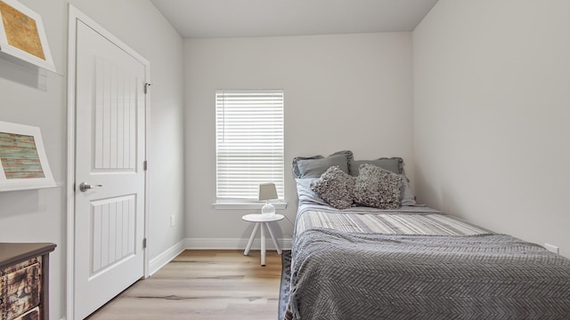 bedroom featuring baseboards and light wood finished floors