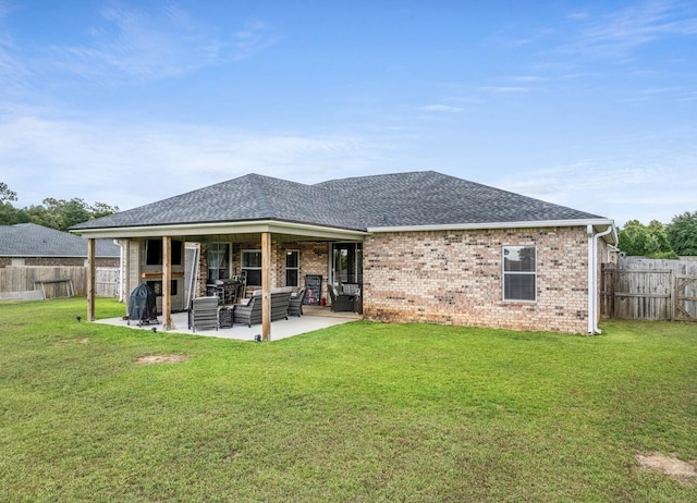 rear view of house featuring a yard, an outdoor living space, and a patio