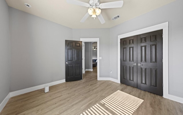 unfurnished bedroom with light hardwood / wood-style flooring, a closet, and ceiling fan