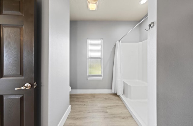 bathroom with a shower with shower curtain and hardwood / wood-style floors