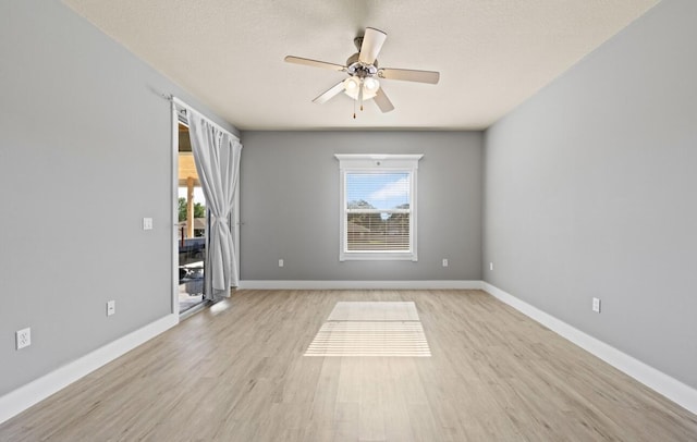 empty room featuring a textured ceiling, ceiling fan, and light wood-type flooring