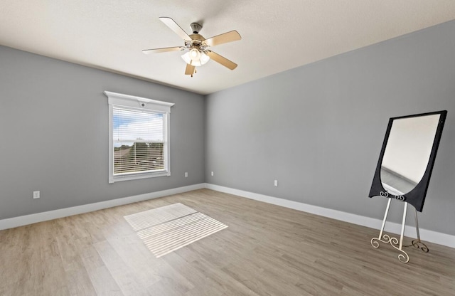 empty room with ceiling fan and light wood-type flooring