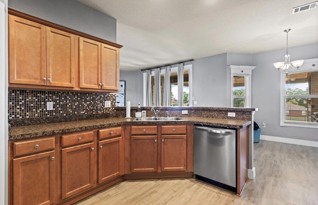 kitchen featuring sink, light hardwood / wood-style flooring, dishwasher, kitchen peninsula, and backsplash