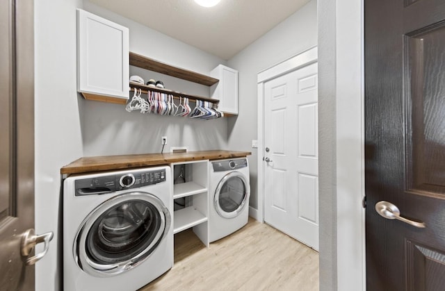 washroom with cabinets, separate washer and dryer, and light hardwood / wood-style flooring