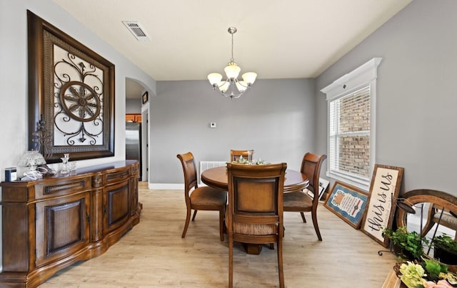 dining room with a notable chandelier and light wood-type flooring