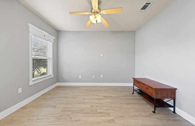 empty room with ceiling fan and light hardwood / wood-style floors