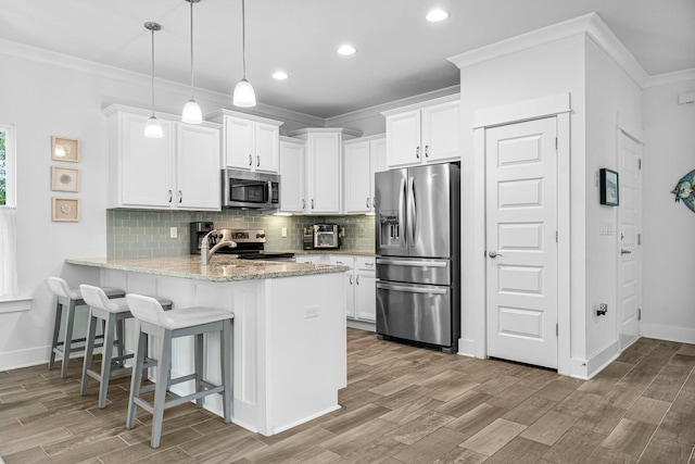 kitchen with tasteful backsplash, kitchen peninsula, white cabinets, stainless steel appliances, and light stone countertops