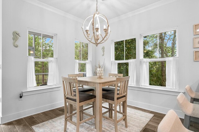 dining space featuring dark wood-type flooring, a notable chandelier, and a wealth of natural light