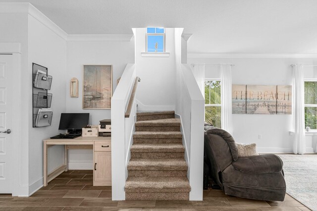 stairway with a healthy amount of sunlight and crown molding