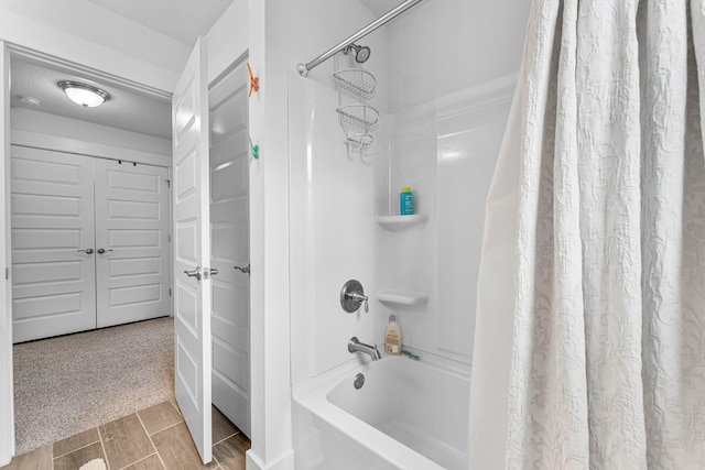 bathroom with shower / bath combo with shower curtain and a textured ceiling