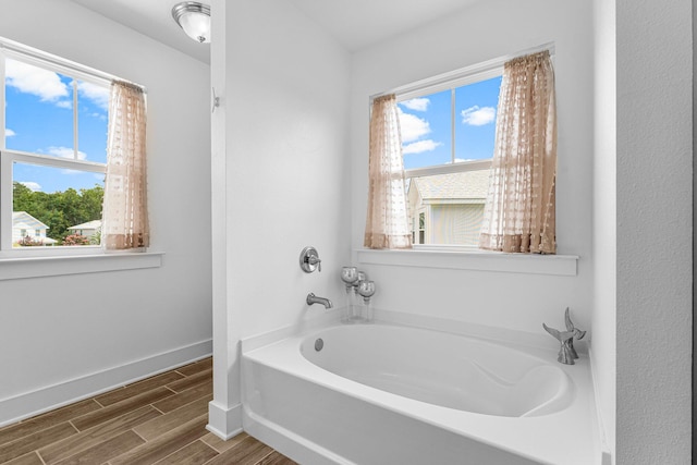 bathroom with a tub and plenty of natural light