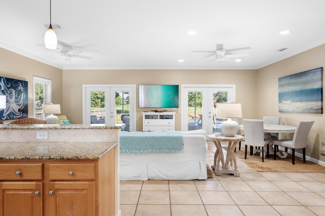 tiled living room with crown molding, french doors, and ceiling fan