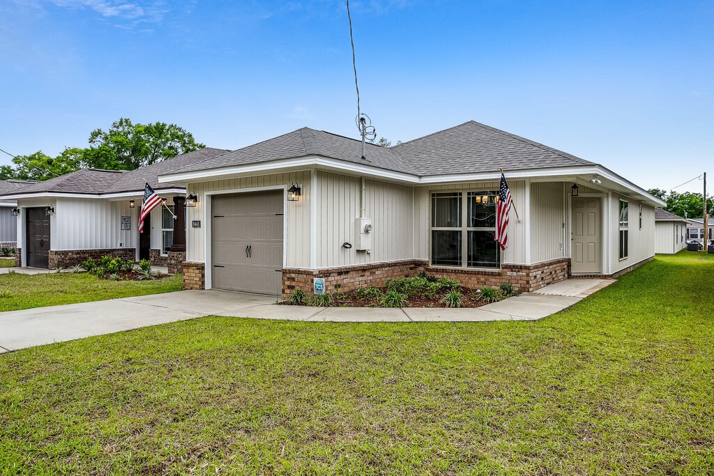 view of front of home with a front yard and a garage