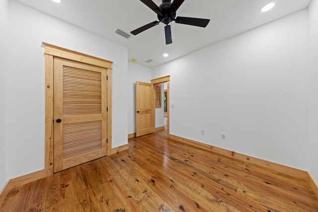 unfurnished bedroom featuring hardwood / wood-style floors, ceiling fan, and a closet