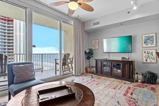 living room with ceiling fan and plenty of natural light