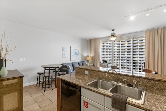 kitchen featuring dishwasher, light tile patterned floors, rail lighting, white cabinets, and sink