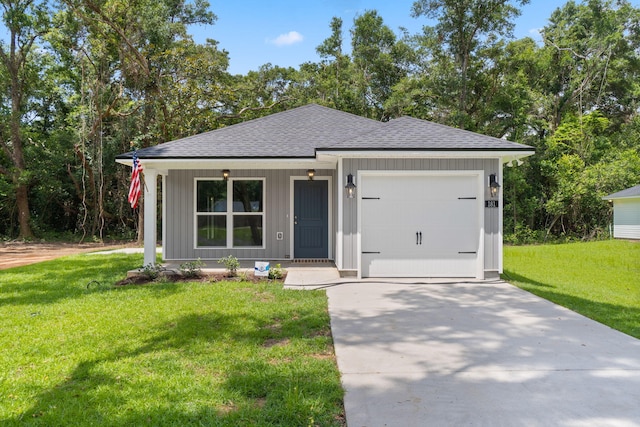 631 Passion Flower St, Defuniak Springs, FL 32433 - view of front facade with roof with shingles, concrete driveway, a garage, a front lawn, and board and batten siding