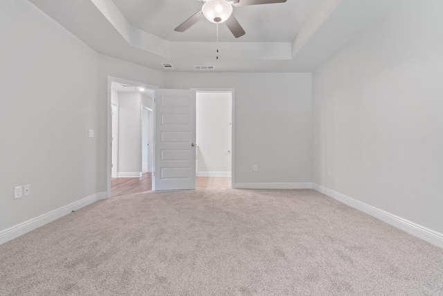 631 Passion Flower St, Defuniak Springs, FL 32433 - unfurnished bedroom with a tray ceiling, light carpet, baseboards, and ceiling fan