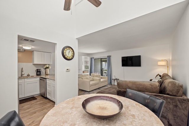 living room with sink, light hardwood / wood-style flooring, and ceiling fan