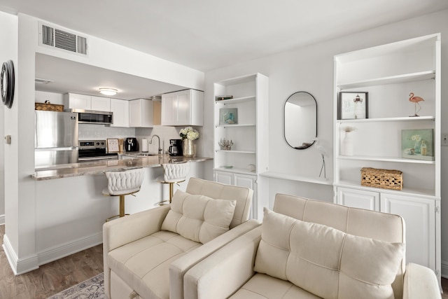 living room featuring sink and light hardwood / wood-style floors