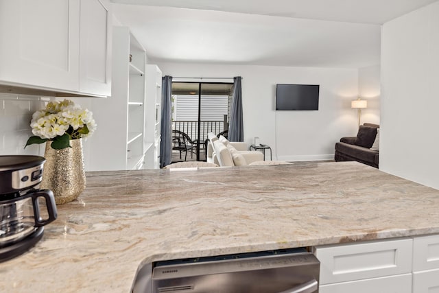 kitchen featuring tasteful backsplash, dishwasher, light stone countertops, and white cabinets