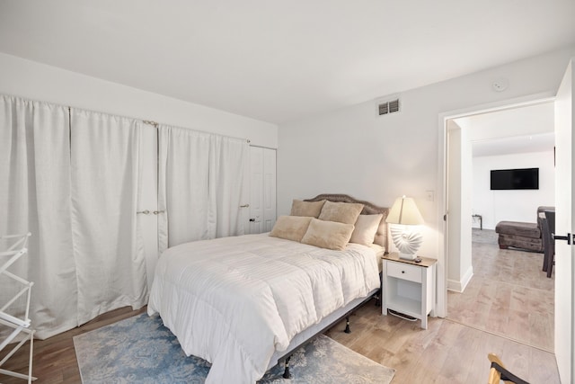 bedroom with light hardwood / wood-style flooring and a closet