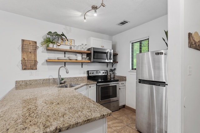 kitchen with white cabinets, light stone countertops, sink, and appliances with stainless steel finishes