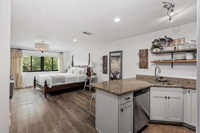 bedroom featuring a textured ceiling, dark hardwood / wood-style floors, and sink