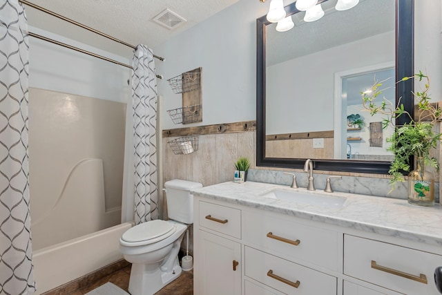 full bathroom with vanity, toilet, tile walls, a textured ceiling, and shower / tub combo with curtain