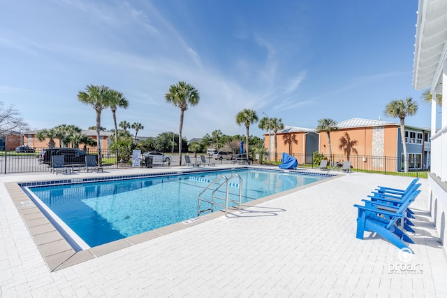 community pool featuring fence and a patio