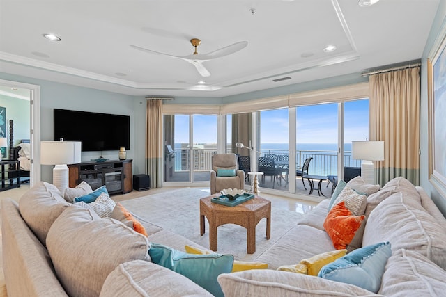 living area with visible vents, a raised ceiling, a ceiling fan, a water view, and recessed lighting