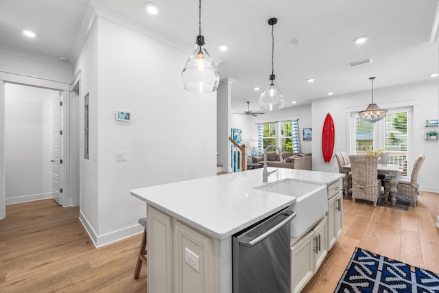 kitchen with hanging light fixtures, sink, dishwasher, and a center island with sink