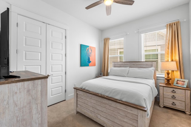 bedroom with light carpet, a closet, and ceiling fan