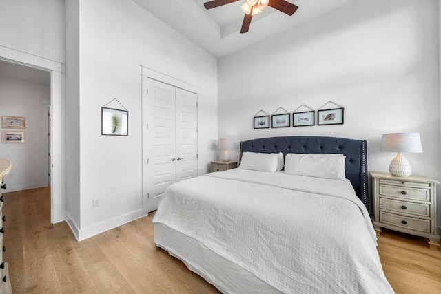 bedroom with ceiling fan, light wood-type flooring, and a closet