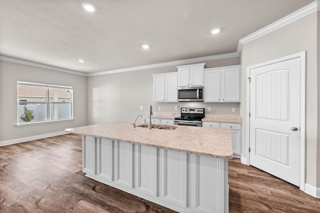 kitchen featuring sink, white cabinets, stainless steel appliances, and a center island with sink