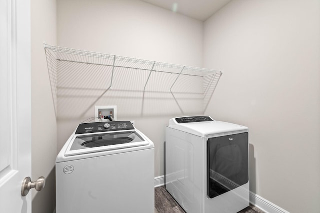 washroom with washing machine and dryer and dark wood-type flooring