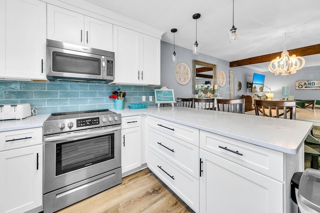 kitchen with kitchen peninsula, decorative backsplash, stainless steel appliances, and hanging light fixtures