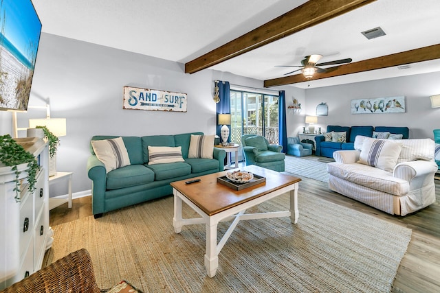 living room featuring beamed ceiling, ceiling fan, and hardwood / wood-style floors