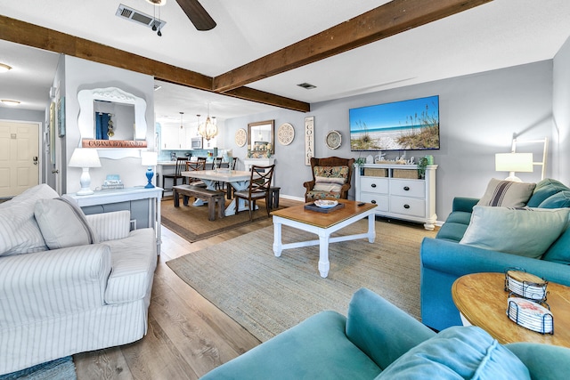 living room featuring ceiling fan, light hardwood / wood-style floors, and beam ceiling