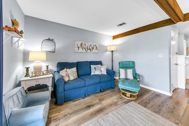 living room with beamed ceiling and light hardwood / wood-style flooring