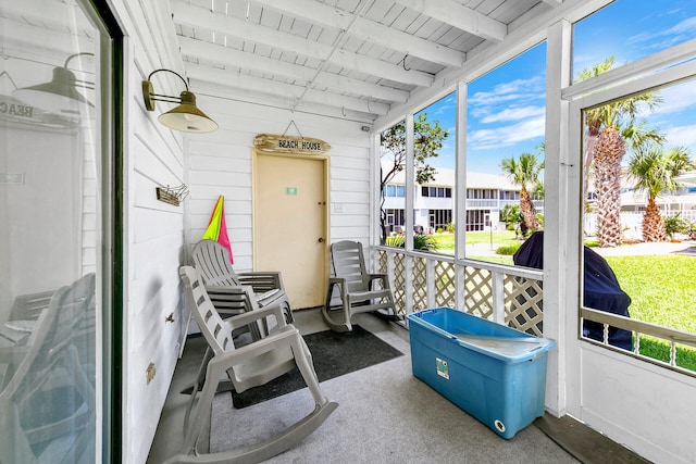 sunroom / solarium featuring beamed ceiling and wood ceiling