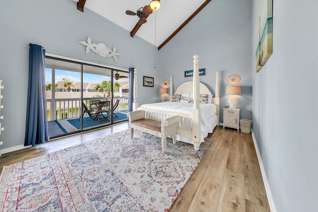 bedroom featuring light wood-type flooring, access to outside, ceiling fan, high vaulted ceiling, and beamed ceiling