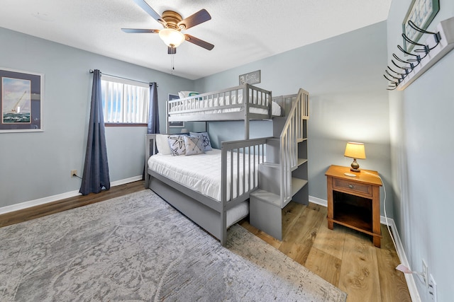 bedroom with hardwood / wood-style floors, a textured ceiling, and ceiling fan