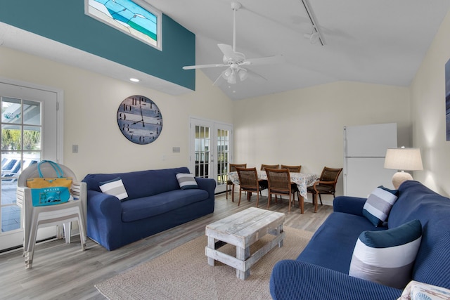 living room featuring a healthy amount of sunlight, french doors, light hardwood / wood-style flooring, and track lighting