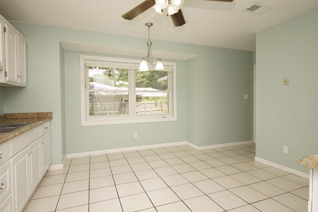 unfurnished dining area with light tile patterned floors, a ceiling fan, visible vents, and baseboards