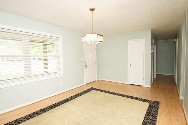 interior space featuring a textured ceiling, a chandelier, and hardwood / wood-style floors